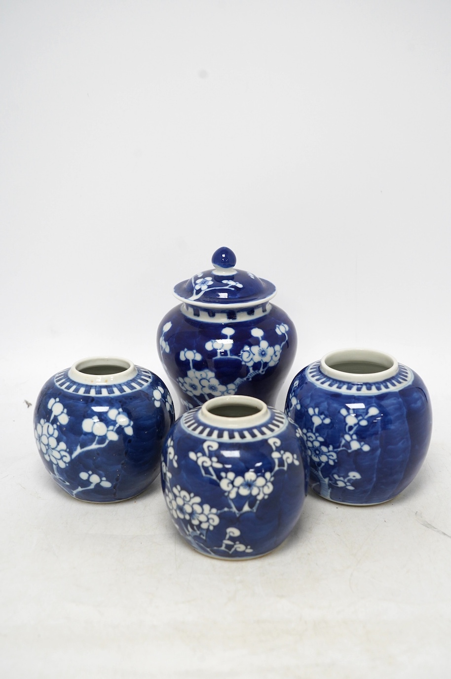 Three Chinese blue and white prunus jars and a similar vase and cover, early 20th century, vase 16.5cm high. Condition - poor as all three jars have the covers missing